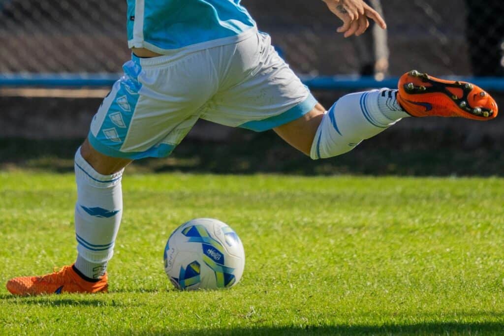 Cropped image of a college student playing football in a match